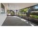 A screened patio shows a view of the backyard and mature trees at 1368 Noell Blvd, Palm Harbor, FL 34683