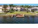 Waterfront backyard with dock, four chairs, screened-in lanai, and a lush green lawn at 16901 Ivy Lake Dr, Odessa, FL 33556