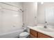 Bright bathroom featuring a bathtub with white tile surround and a vanity with wood cabinetry at 16901 Ivy Lake Dr, Odessa, FL 33556