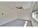 An airy bedroom with neutral carpet, modern ceiling fan, and abundant natural light from a large window at 1832 Bough Ave # 3, Clearwater, FL 33760