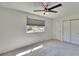 Bright bedroom with a modern ceiling fan, neutral carpet and a window offering natural light, next to closet at 1832 Bough Ave # 3, Clearwater, FL 33760