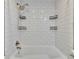 Bright bathroom with a tiled shower showcasing built-in shelves, a shower wand and modern fixtures at 1832 Bough Ave # 3, Clearwater, FL 33760