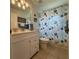 Bright bathroom featuring white vanity, tile floor, and seashell themed shower curtain at 2021 E Del Webb Blvd, Sun City Center, FL 33573