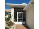 Welcoming screened-in front entry with decorative security door and manicured landscaping at 2021 E Del Webb Blvd, Sun City Center, FL 33573