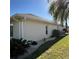 Home exterior features white stucco, lush landscaping, and a well-maintained lawn at 2021 E Del Webb Blvd, Sun City Center, FL 33573