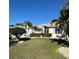 Charming single-story home with lush lawn, tropical landscaping, and decorative rock features at 2021 E Del Webb Blvd, Sun City Center, FL 33573