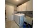 Functional laundry room includes washer, dryer, sink, and ample storage at 2021 E Del Webb Blvd, Sun City Center, FL 33573
