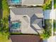 Aerial view of a house, highlighting the roof design, screened-in pool, and well-maintained landscaping at 23523 Gracewood Cir, Land O Lakes, FL 34639