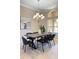 Elegant dining room features a modern chandelier, large window, and stylish furniture at 23523 Gracewood Cir, Land O Lakes, FL 34639