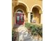 Inviting front porch featuring a red double door, elegant columns, and manicured hedges, enhancing curb appeal at 23523 Gracewood Cir, Land O Lakes, FL 34639