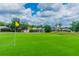 Scenic view of the golf course featuring lush green grass and well-maintained homes in the background at 23523 Gracewood Cir, Land O Lakes, FL 34639