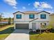 Charming two-story home with landscaped yard and a two-car garage with a blue sky overhead at 248 Argyll Dr, Spring Hill, FL 34609