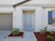 Inviting front entrance with manicured landscaping, a gray colored door, and a two-car garage at 248 Argyll Dr, Spring Hill, FL 34609