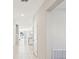 Hallway leads to a kitchen and living room, featuring white tile flooring and freshly painted walls at 248 Argyll Dr, Spring Hill, FL 34609