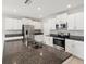 Modern kitchen featuring white cabinets, stainless steel appliances, and granite countertops with a kitchen island at 248 Argyll Dr, Spring Hill, FL 34609