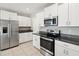Modern kitchen with stainless steel appliances, white cabinets, and granite countertops at 248 Argyll Dr, Spring Hill, FL 34609