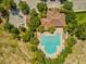 Aerial view of community pool with lounge chairs and parking. Lush green trees surround the area at 248 Argyll Dr, Spring Hill, FL 34609