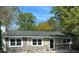Charming single-story home featuring stone accents and a well-maintained yard under a clear blue sky at 26419 Rolling Acres E Dr, Brooksville, FL 34602