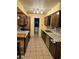 Galley kitchen featuring dark wood cabinetry, granite countertops, and stainless steel appliances and tile flooring at 26419 Rolling Acres E Dr, Brooksville, FL 34602