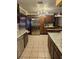 Well-appointed kitchen featuring dark wood cabinets, tile flooring, stainless steel appliances, and granite countertops at 26419 Rolling Acres E Dr, Brooksville, FL 34602