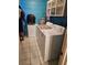 Laundry room showcasing white appliances and overhead shelving for extra storage at 26419 Rolling Acres E Dr, Brooksville, FL 34602