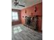 Living room features stone fireplace with mantel, a window, and wood-look flooring at 26419 Rolling Acres E Dr, Brooksville, FL 34602
