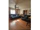 Living room showcasing two black leather sofas, wood floors and rustic decor at 26419 Rolling Acres E Dr, Brooksville, FL 34602
