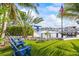 Beautiful backyard with blue Adirondack chairs overlooking the water and boat docks at 3006 Christophers Watch Ln, Ruskin, FL 33570