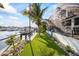 Lush landscaping with artificial grass and a dock with water views at 3006 Christophers Watch Ln, Ruskin, FL 33570