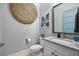 Stylish powder room featuring beach themed decor, a decorative mirror, and a modern sink vanity at 3006 Christophers Watch Ln, Ruskin, FL 33570
