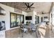 Relaxing covered patio with dining area, TV, ceiling fans, and sliding glass doors for indoor/outdoor living at 3006 Christophers Watch Ln, Ruskin, FL 33570