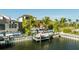 A boat sits on a lift at the rear of an upscale home in a waterfront neighborhood at 3006 Christophers Watch Ln, Ruskin, FL 33570