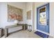 Inviting foyer with a blue front door, bench with vase, and decorative wall art at 3006 Christophers Watch Ln, Ruskin, FL 33570