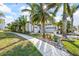Beautiful two-story white home with a brick driveway and lush tropical landscaping on a sunny day at 3006 Christophers Watch Ln, Ruskin, FL 33570