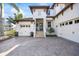 Beautiful two-story white home with a brick driveway, lush tropical landscaping and three-car garage at 3006 Christophers Watch Ln, Ruskin, FL 33570