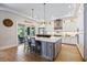 Stylish kitchen showcasing a large island, white cabinetry, stainless steel appliances, and ample lighting at 3006 Christophers Watch Ln, Ruskin, FL 33570