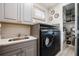 Well-organized laundry room with modern washer and dryer, custom cabinets, and countertop space at 3006 Christophers Watch Ln, Ruskin, FL 33570