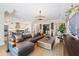 Open concept living space with a large sectional couch, hardwood floors and an adjacent modern kitchen at 3006 Christophers Watch Ln, Ruskin, FL 33570