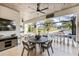Inviting outdoor patio with a ceiling fan, dining set, TV, and views of the lush landscaping and waterfront at 3006 Christophers Watch Ln, Ruskin, FL 33570