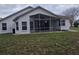 Back of house features a screened in patio, and nice yard at 3292 Dow Ln, Spring Hill, FL 34609