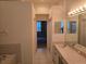 Hall bathroom features a long vanity and a tiled tub next to an entry to another bedroom at 3292 Dow Ln, Spring Hill, FL 34609