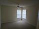 Cozy bedroom featuring neutral carpet, two windows with blinds, and a ceiling fan at 3292 Dow Ln, Spring Hill, FL 34609