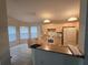 Functional kitchen featuring wooden cabinetry, white appliances, breakfast bar and tiled flooring at 3292 Dow Ln, Spring Hill, FL 34609