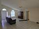 Spacious living room with tile flooring, high ceilings, and an ornate wooden cabinet at 3292 Dow Ln, Spring Hill, FL 34609