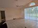Living Room features tile floors, fan, high ceilings, and access to backyard at 3292 Dow Ln, Spring Hill, FL 34609