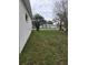 Spacious yard with lush lawn and side view of the home at 3292 Dow Ln, Spring Hill, FL 34609