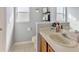 Well-lit bathroom with a cream sink, wooden cabinet, and a decorative shelf at 3412 Trapnell Ridge Dr, Plant City, FL 33567