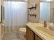 Cozy bathroom features a shower with a curtain, shelves, toilet and sink at 3412 Trapnell Ridge Dr, Plant City, FL 33567