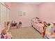 Charming pink bedroom featuring a twin bed, plush toys, and unicorn themed decor at 3412 Trapnell Ridge Dr, Plant City, FL 33567