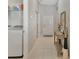 Bright hallway featuring tile flooring, access to the laundry area, and a decorative table next to the front door at 3412 Trapnell Ridge Dr, Plant City, FL 33567